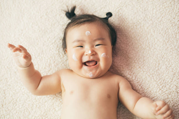 Bébé avec de la crème sur le visage adaptée à son type de peau