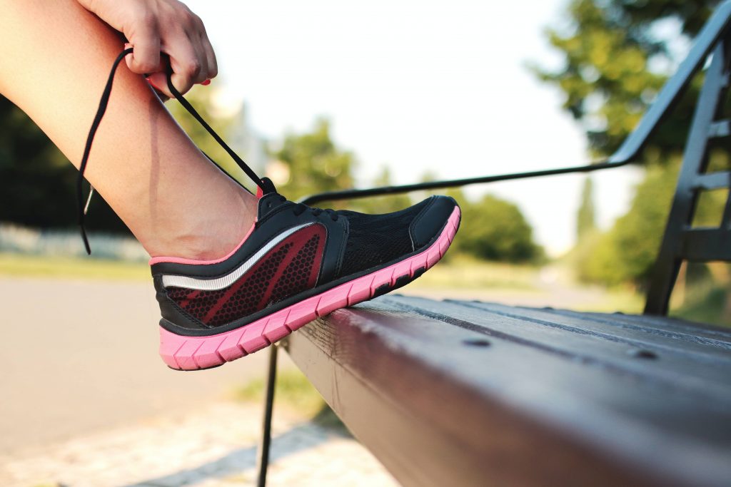 Personne qui enfile ses chaussures de sport pour se remettre en forme